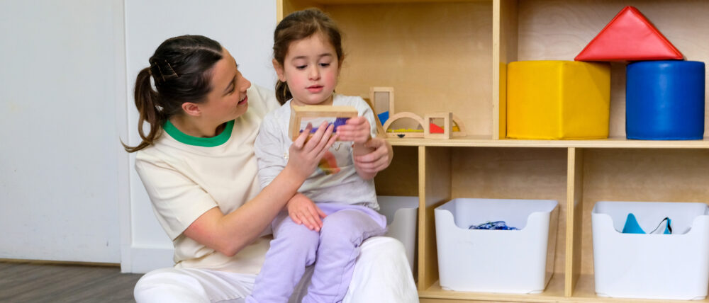 Child on therapist lap playing